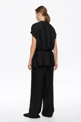 Pantalón negro de corte recto y tobillero, con tiro bajo, bolsillos alforja y mini cinturilla ajustable con cordón.