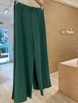 Pantalón liso verde con recorte delantero, botón al tono y cintura elástica con pasacinto.