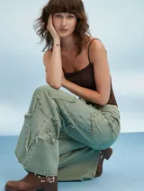 Pantalón jean de tiro alto color verde oliva, corte acampanado y detalles rotos con flecos.