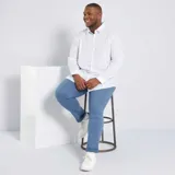 Camisa blanca de sarga, corte recto, con mangas largas y botones frontales.