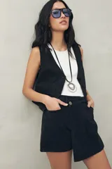 Short pollera de denim azul con corte asimétrico y cierre con botón.