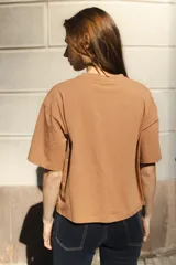Remera negra de algodón con corte cuadrado, cuello redondo y logo bordado en color naranja.