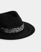 Sombrero negro de paja con ala ancha y cinta estampada de pañuelo en blanco y negro.