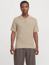 Polo de punto color beige con cuello clásico, mangas cortas y cierre con botones.