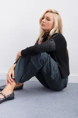 Pantalón cargo de mujer color verde oscuro, tiro medio, corte recto con ajuste en los tobillos mediante cierres metálicos. Confeccionado en gabardina elastizada, cuenta con bolsillos cargo laterales y cinturón interno con hebilla.