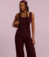 Pantalón pantalona color borgoña de tiro alto y corte palazzo, confeccionado en cupro con pliegues delanteros.