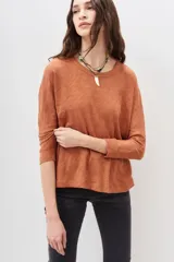 Remera de manga larga color terracota con textura jaspeada, confeccionada en algodón peruano. Presenta un calce holgado con mangas que se ensanchan debajo del brazo y se ajustan en la muñeca.