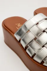 Sandalias negras de cuero con plataforma pareja y tiras de cuero tejidas en la parte superior.