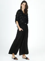 Pantalón de lino negro con tajos a los costados, diseño fluido y ligero.