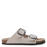 Sandalias planas color beige con dos tiras anchas con hebillas metálicas plateadas.