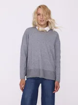 Sweater gris con terminación en lurex y botones decorativos, de corte relajado y mangas largas.