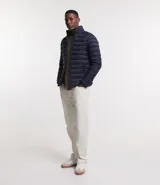 Campera puffer ultraligera color beige, con cuello alto, cierre por cremallera y bolsillos con cremallera. Incluye bolso de almacenamiento.