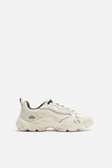 Zapatillas grises con cordones, capellada combinada y suela chunky con diseño irregular.