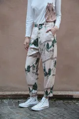 Pantalón de corte recto con estampado de leopardos y hojas de palmera en tonos beige, marrón y verde.