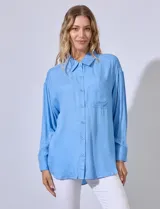 Camisa bordada de rayón color azul, con cuello con solapa y bolsillo aplicado en la parte delantera.