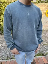 Buzo azul de algodón con cuello redondo y logo bordado en el pecho.