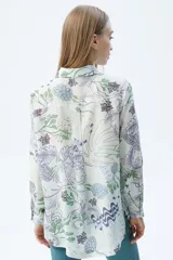 Camisa de tencel color crudo con estampado orgánico en tonos verdes y lilas. Presenta un calce recto, mangas largas y cierre frontal con botones.