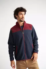 Campera polar para hombre, color azul marino con canesú y cuello en color borgoña. Tiene cierre frontal completo, bolsillos laterales con cierre, puños y ruedo elastizados, y logo estampado en el pecho.