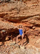 Traje de baño entero color azul vibrante, con textura tejida o gofrada. Diseño de vedetina con escote corazón y aro, tirantes finos ajustables y detalles de costura tipo corset en el torso.