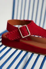 Sandalia negra con diseño de tiras y hebilla, de estilo elegante y cómodo.