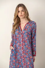 Vestido largo con estampado floral en tonos rosa y verde sobre fondo blanco. Tiene cuello con volantes, cierre frontal con botones y mangas largas con puños elásticos.