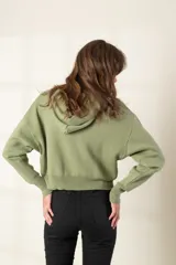 Sweater de tejido con capucha color verde, fabricado en 100% algodón y de corte relajado.