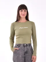 Remera blanca de manga larga con cuello redondo y estampado pequeño con la frase 'Busy ignoring someone' en el pecho.
