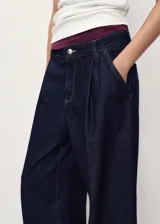 Pantalón de jeans ancho (wideleg) de tiro medio, color azul oscuro, con pinzas delanteras y cuatro bolsillos.