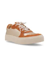 Zapatillas bajas con estampado de vaca en blanco y negro, detalles en gamuza azul y suela marrón.