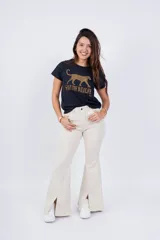 Pantalón Oxford color crema con corte acampanado y aberturas en el ruedo.