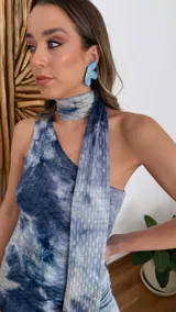 Vestido largo de fiesta con estampado tie-dye en tonos de azul y blanco. Presenta escote halter con lazos y abertura lateral en la falda.