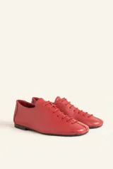 Zapatos chatos de cuero color bordó, con cordones finos y punta cuadrada.