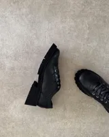 Zapatos acordonados de cuero vacuno color negro, con suela track.