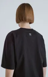 Remerón negro de corte extra oversize con hombros caídos, cuello redondo y doble costura.