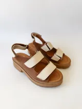 Sandalias de cuero color marrón con plataforma y dos tiras anchas de cuero crudo con velcro.