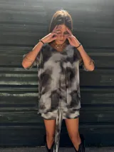 Remera gris con estampado tie-dye en tonos grises y negros, corte holgado y mangas cortas.
