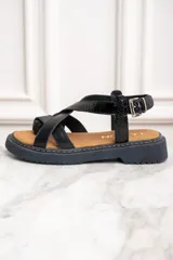Sandalias de cuero negro con tiras cruzadas y hebilla al tobillo.