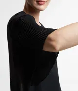 Blusa de gasa negra con cuello redondo y mangas cortas amplias texturizadas con transparencias.