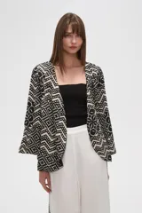 Kimono de poliéster con estampado geométrico en blanco y negro, mangas 3/4, corte holgado y cuello en V.