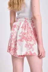 Short casual de lino color crudo con estampado de motivos tropicales en color rosado.