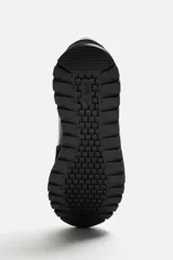Zapatilla deportiva negra con detalles en piel y acabado serraje.