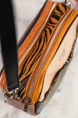 Bandolera rectangular con correa larga regulable, confeccionada en cuero vegano con combinación de texturas y colores: parte superior en beige liso, parte central en verde con efecto piel de cocodrilo y parte inferior en marrón.