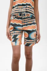 Bermuda de denim con estampado abstracto en tonos naranja, celeste y negro.