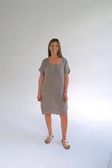 Vestido corto color gris topo, de lino italiano, corte suelto, escote redondo, mangas cortas y botones decorativos en los costados.