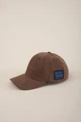 Gorro de tela de pana color tostado, con visera y parche en el costado.