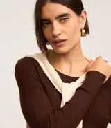 Suéter negro de punto acanalado con mangas largas y cuello redondo.