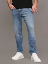 Pantalón de jean celeste, corte slim tapered, con bragueta con cremallera y diseño de cinco bolsillos. Calvin Klein.