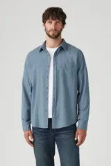 Camisa celeste de lino con un bolsillo en el pecho, de manga larga y corte clásico.