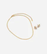 Conjunto de collar y aros dorados con forma de flor y detalle de zirconia.