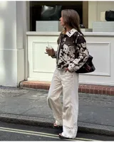 Campera de poliéster con diseño de estampado animal print en tonos blanco y marrón.